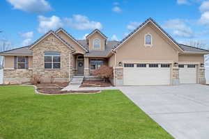 View of front of property with a garage and a front lawn