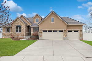 View of front of home with a garage and a front lawn