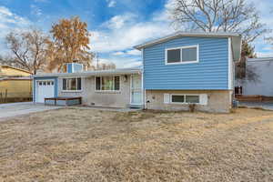 Tri-level home with a garage and a front lawn