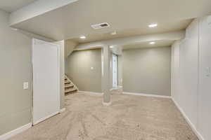 Basement with light colored carpet