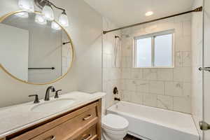 Full bathroom with vanity, toilet, and tiled shower / bath