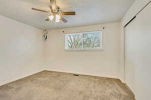 Spare room with ceiling fan and carpet flooring