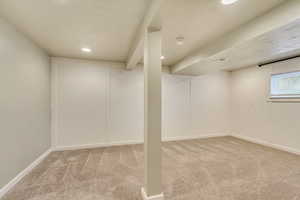 Basement featuring light colored carpet