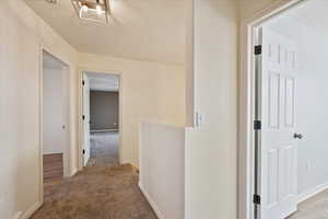 Corridor with light colored carpet