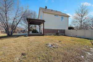 View of home's exterior with a pergola and a lawn