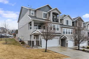 View of front of house with a garage, a front yard, and central air condition unit