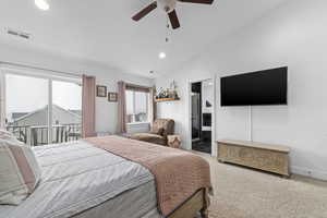 Carpeted bedroom featuring ceiling fan and vaulted ceiling