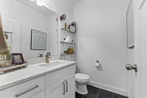 Bathroom with tile patterned floors, toilet, and vanity