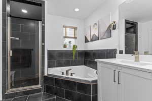 Bathroom featuring vanity, tile patterned floors, and plus walk in shower