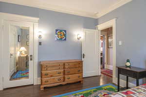 Bedroom with ornamental molding and dark hardwood / wood-style flooring