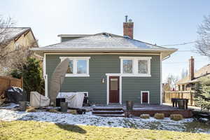 Snow covered rear of property featuring a wooden deck