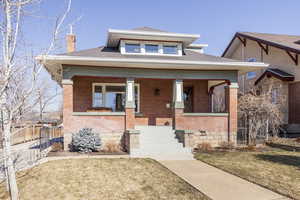 View of front of home with a porch and a front yard