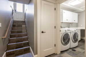 Laundry area featuring cabinets and washer and clothes dryer