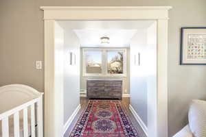 Corridor featuring a baseboard radiator and dark hardwood / wood-style floors