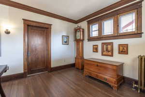 Interior space featuring ornamental molding and dark hardwood / wood-style flooring