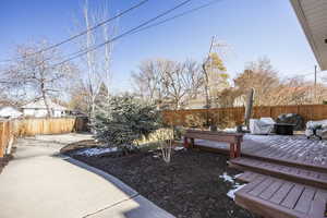 View of yard with a wooden deck and a patio