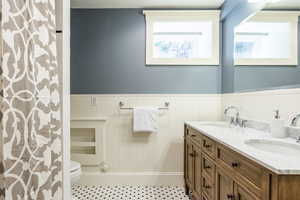 Bathroom featuring a shower with curtain, vanity, and toilet