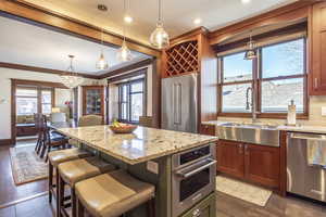 Kitchen featuring appliances with stainless steel finishes, hanging light fixtures, sink, and a kitchen island