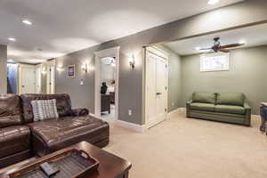 Carpeted living room with ceiling fan