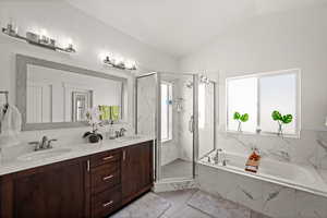 Bathroom with vanity, lofted ceiling, and separate shower and tub