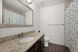 Bathroom featuring wood-type flooring, vanity, and toilet