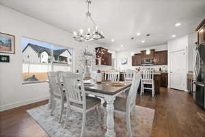 Dining area with an inviting chandelier and dark hardwood / wood-style flooring