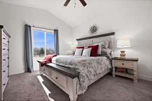 Bedroom with lofted ceiling, ceiling fan, and dark colored carpet