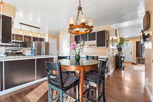 Dining space with an inviting chandelier, baseboards, and wood finished floors