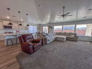 Living room with hardwood / wood-style floors, a textured ceiling, and ceiling fan