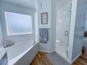 Bathroom featuring hardwood / wood-style flooring and independent shower and bath