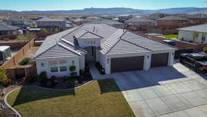 View of front of property with a mountain view, a garage, and a front lawn