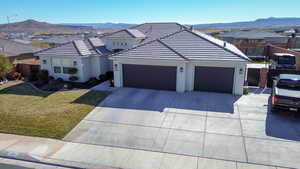 View of front of home with a mountain view, a garage, and a front lawn