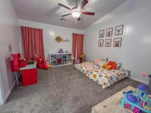 Carpeted bedroom featuring ceiling fan