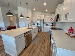 Kitchen with white cabinetry and appliances with stainless steel finishes