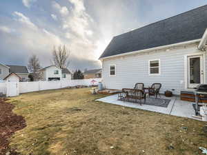 Back of property with a patio and a lawn