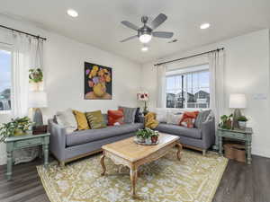 Living room with ceiling fan and dark hardwood / wood-style floors