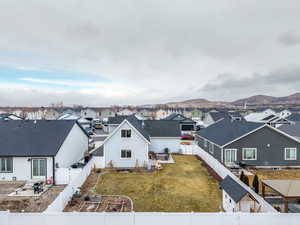 Back of property featuring a mountain view and a lawn