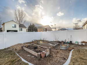 View of yard at dusk featuring planter boxes.