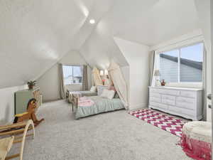 Bedroom featuring lofted ceiling, light carpet, and a textured ceiling