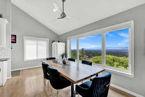 Dining room with lofted ceiling, ceiling fan, and light hardwood / wood-style flooring