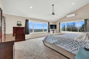 Bedroom with lofted ceiling, ceiling fan, a wall unit AC, carpet floors, and ornamental molding