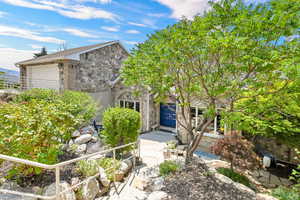 View of property hidden behind natural elements featuring a garage