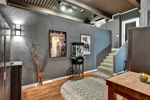 Interior space featuring beamed ceiling, an AC wall unit, and hardwood / wood-style floors