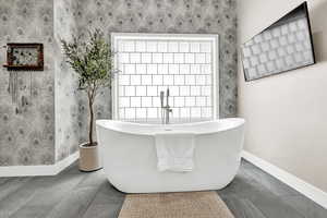 Bathroom featuring a washtub and plenty of natural light