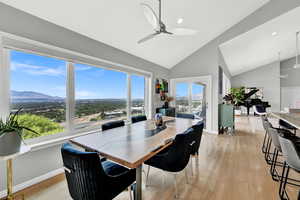 Dining room featuring ceiling fan, a mountain view, high vaulted ceiling, and light wood-type flooring