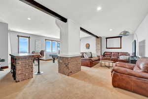 Carpeted living room with beam ceiling