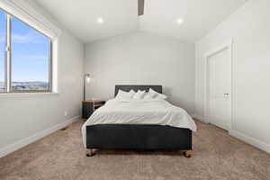 Carpeted bedroom featuring lofted ceiling and ceiling fan