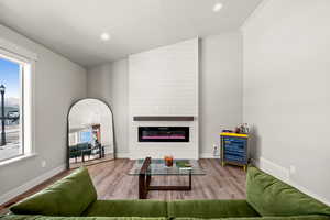 Living room featuring plenty of natural light, hardwood / wood-style floors, beverage cooler, and a fireplace