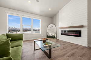 Living room featuring a mountain view, vaulted ceiling, and wood-type flooring