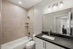 Full bathroom with vanity, toilet, and tiled shower / bath